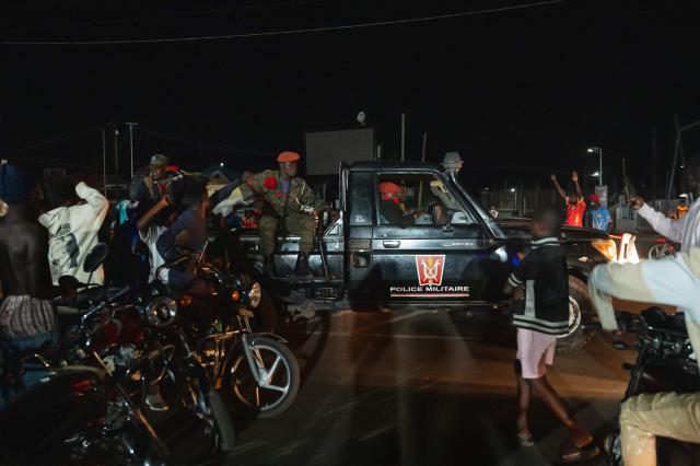 Military Police officers patrol in a pickup truck through the streets of Bunia as Congolese supporters celebrate the Leopards' equalizing goal in a street in Bunia at night during a FIFA World Cup match between DR Congo and Portugal in Bunia, Ituri Province, Democratic Republic of Congo, on June 17, 2026. Ituri, a remote province in northeastern Congo, is at the epicenter of the 17th Ebola outbreak, declared on May 15 in the DRC. The virus has infected 837 people and caused 196 deaths so far, according to the latest official figures.
In the city of Bunia alone, 215 cases of infection have been confirmed, while the DRCs testing capacity is limited. The scale of the health crisis is still unknown, scientists, aid workers, and international health authorities acknowledge.
But for 90 minutes of the match, some of the roughly 100 million inhabitants say they were able to escape the worries linked to the epidemic, the conflict in the east of the country, and the violence of armed groups. (Photo by Jospin Mwisha / AFP)