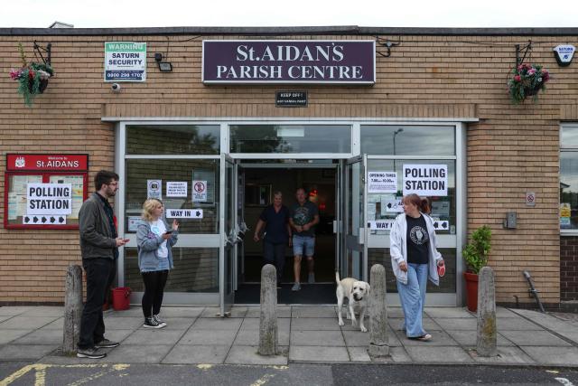 People walk out of a makeshift polling station at a parish centre in Winstanley, Wigan, part of the parliamentary constituency for the Makerfield by-election, after polls opened at 7am on June 18, 2026. Britain holds a unique vote on June 18 that could trigger the endgame for Labour leader Keir Starmer's beleaguered premiership, or win him a reprieve. (Photo by Darren Staples / AFP)