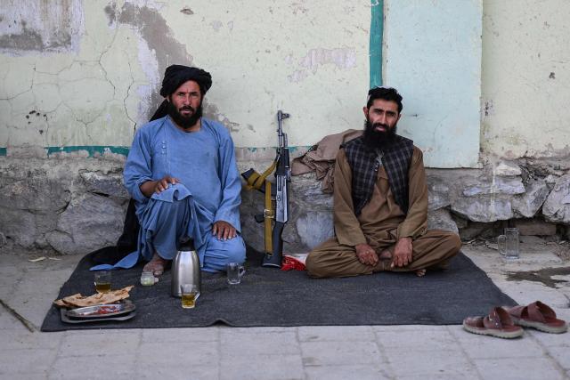 Taliban security personnel pose for a photograph while having breakfast at a checkpoint in Kandahar on June 18, 2026. (Photo by Sanaullah SEIAM / AFP)