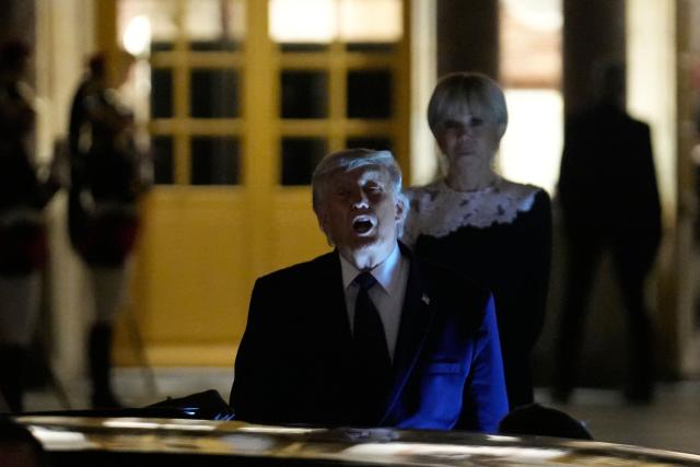 US President Donald Trump (c) walks to the presidential limousine alongside France's First Lady Brigitte Macron following a dinner marking the 250th anniversary of US independence at the Château de Versailles in Versailles, southwest of Paris, on June 17, 2026. (Photo by Michel Euler / POOL / AFP)