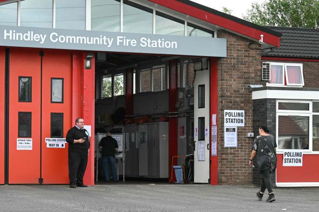 A resident (R) walks into a makeshift polling station set up at a fire station in Hindley, part of the parliamentary constituency for the Makerfield by-election, after polls opened on June 18, 2026. Britain holds a unique vote on June 18 that could trigger the endgame for Labour leader Keir Starmer's beleaguered premiership, or win him a reprieve. (Photo by Oli SCARFF / AFP)