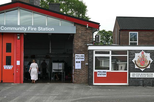 A resident (L) walks into a makeshift polling station set up at a fire station in Hindley, part of the parliamentary constituency for the Makerfield by-election, after polls opened on June 18, 2026. Britain holds a unique vote on June 18 that could trigger the endgame for Labour leader Keir Starmer's beleaguered premiership, or win him a reprieve. (Photo by Oli SCARFF / AFP)