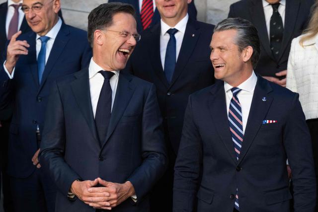 TOPSHOT - NATO Secretary General Mark Rutte (L) and US Defense Secretary Pete Hegseth react as they pose with Defence Ministers during a family photograph on the sidelines of a NATO Defence Ministers meeting at the NATO headquarters, in Brussels, on June 18, 2026. (Photo by JOHN THYS / AFP)