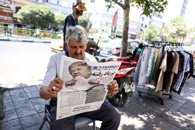 A man reads a copy of the Iranian daily newspaper Hamshahri bearing an image of the US president and a headline that reads "Gone with the wind" at a kiosk in Tehran on June 18, 2026. The United States and Iran have signed a deal to end the Middle East war, with a ceremony set for June 19 in Switzerland that will mark the start of a 60-day negotiation period. The memorandum of understanding aims to put an end to months of conflict initiated by US-Israeli strikes on Iran in February, which wreaked chaos across the region and rattled the global economy. (Photo by AFP) / 