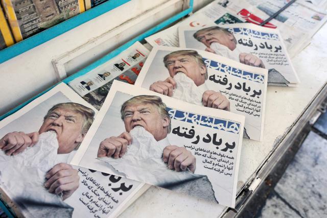 Copies of the Iranian daily newspaper Hamshahri bearing an image of the US president and a headline that reads "Gone with the wind" are displayed at a kiosk in Tehran on June 18, 2026. The United States and Iran have signed a deal to end the Middle East war, with a ceremony set for June 19 in Switzerland that will mark the start of a 60-day negotiation period. The memorandum of understanding aims to put an end to months of conflict initiated by US-Israeli strikes on Iran in February, which wreaked chaos across the region and rattled the global economy. (Photo by AFP) / 