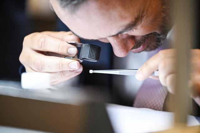 Belgium's Deputy Prime Minister and Minister of Foreign Affairs Maxime Prevot examines with a magnifying glass traceable artisanally mined diamonds from DR Congo during their sales at the Antwerp World Diamond Centre (AWDC) in Antwerp on June 18, 2026. The diamonds originate from the Kasai region and were mined as part of OrigemA, a Belgian-Congolese initiative that guarantees a fully transparent chain. (Photo by Tom Goyvaerts / Belga / AFP) / Belgium OUT