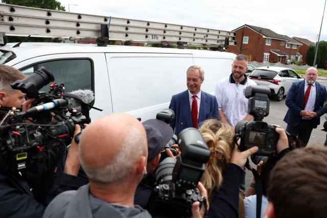 Reform UK's candidate Rob Kenyon and Reform UK Leader Nigel Farage pose for a photo as Kenyon arrives to cast his vote in the the Makerfield by-election, at a polling station in Winstanley, part of the Makerfield parliamentary constituency, in north-west England on June 18, 2026. Britain holds a unique vote on June 18 that could trigger the endgame for Labour leader Keir Starmer's beleaguered premiership, or win him a reprieve. (Photo by Darren Staples / AFP)