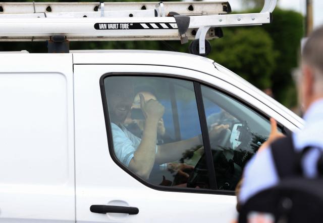 Reform UK's candidate Rob Kenyon gives a thumbs up as he drives away in his van with Reform UK Leader Nigel Farage, after voting in the the Makerfield by-election, at a polling station in Winstanley, part of the Makerfield parliamentary constituency, in north-west England on June 18, 2026. Britain holds a unique vote on June 18 that could trigger the endgame for Labour leader Keir Starmer's beleaguered premiership, or win him a reprieve. (Photo by Darren Staples / AFP)