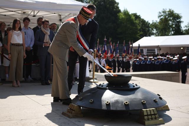 Former General Chief of Staff of the French armed Forces Thierry Burkhard (centre L) rekindles the flame of the Resistance during the commemorative ceremony for the 86th anniversary of the Appeal of 18 June, in Mont Valerien on June 18, 2026. (Photo by SIMON WOHLFAHRT / POOL / AFP)