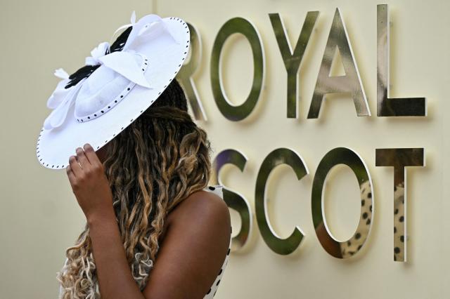 Racegoers pose for a photo as they arrive on the third day of the Royal Ascot horse racing meeting in Ascot, west of London, on June 18, 2026. (Photo by JUSTIN TALLIS / AFP)