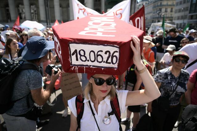 A protester holds a placard shaped as a coffin during a day of action called by journalists' unions to defend the news industry, at Place de la Bourse central Paris on June 18, 2026. (Photo by JULIEN DE ROSA / AFP)