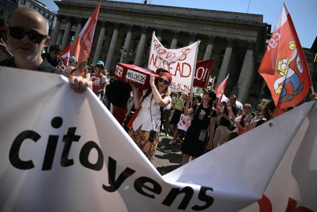 Protesters hold placards and chant slogans as they take part in a demonstration during a day of action called by journalists' unions to defend the news industry, at Place de la Bourse central Paris on June 18, 2026. (Photo by JULIEN DE ROSA / AFP)