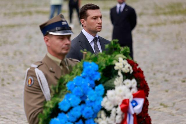French far-right Rassemblement National (RN) party's President, member of the European Parliament and president of the Patriots for Europe (PfE) group Jordan Bardella, takes part in a wreath laying ceremony at the Monument to the Ghetto Heroes in Warsaw, Poland on June 18, 2026. Jordan Bardella is in Warsaw to meet with leaders of Poland’s far right, marking the latest stop on his overseas tour aimed at strengthening his European alliances just a few months before the French presidential election. (Photo by Wojtek RADWANSKI / AFP)