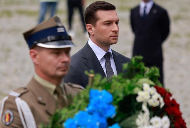 French far-right Rassemblement National (RN) party's President, member of the European Parliament and president of the Patriots for Europe (PfE) group Jordan Bardella, takes part in a wreath laying ceremony at the Monument to the Ghetto Heroes in Warsaw, Poland on June 18, 2026. Jordan Bardella is in Warsaw to meet with leaders of Poland’s far right, marking the latest stop on his overseas tour aimed at strengthening his European alliances just a few months before the French presidential election. (Photo by Wojtek RADWANSKI / AFP)