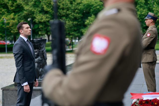 French far-right Rassemblement National (RN) party's President, member of the European Parliament and president of the Patriots for Europe (PfE) group Jordan Bardella, takes part in a wreath laying ceremony at the Monument to the Ghetto Heroes in Warsaw, Poland on June 18, 2026. Jordan Bardella is in Warsaw to meet with leaders of Poland’s far right, marking the latest stop on his overseas tour aimed at strengthening his European alliances just a few months before the French presidential election. (Photo by Wojtek RADWANSKI / AFP)