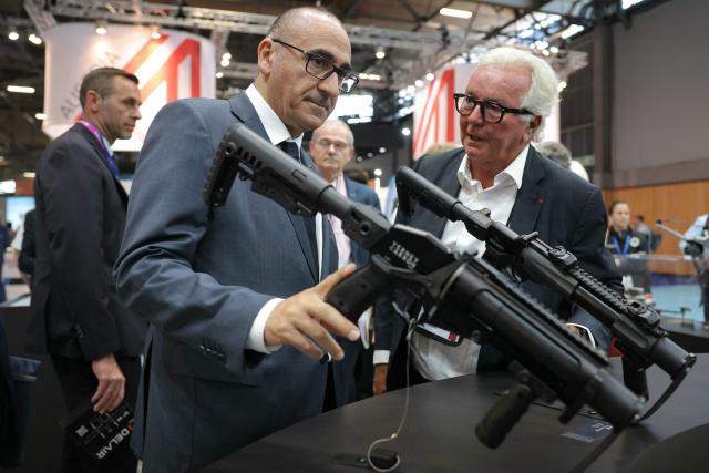France's Interior Minister Laurent Nunez (L) reacts as he is presented a rubber bullet launcher of Verney-Carron by President of Rivolier Arnaud Van Robais at Eurosatory defence and security trade fair in Villepinte on the outskirts of Paris, on June 18, 2026. (Photo by Thomas SAMSON / AFP)