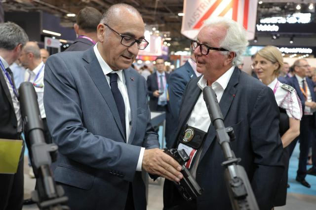 France's Interior Minister Laurent Nunez (L) reacts as he speaks with President of Rivolier Arnaud Van Robais at Eurosatory defence and security trade fair in Villepinte on the outskirts of Paris, on June 18, 2026. (Photo by Thomas SAMSON / AFP)