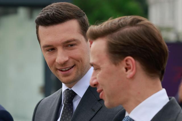 French far-right Rassemblement National (RN) party's President, member of the European Parliament and president of the Patriots for Europe (PfE) group Jordan Bardella (L) and Poland's ultranationalist Confederation party (Konfederacja) president and Deputy Marshal of the Sejm of the Republic of Poland Krzysztof Bosak   attend a ceremony at the tomb of the Unknown Soldier at the Marshal Jozef Pilsudski Square in Warsaw, Poland on June 18, 2026. Jordan Bardella is in Warsaw to meet with leaders of Polands far right, marking the latest stop on his overseas tour aimed at strengthening his European alliances just a few months before the French presidential election. (Photo by Wojtek RADWANSKI / AFP)