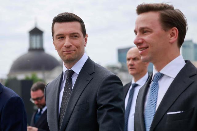 French far-right Rassemblement National (RN) party's President, member of the European Parliament and president of the Patriots for Europe (PfE) group Jordan Bardella (L) and Poland's ultranationalist Confederation party (Konfederacja) president and Deputy Marshal of the Sejm of the Republic of Poland Krzysztof Bosak   attend a ceremony at the tomb of the Unknown Soldier at the Marshal Jozef Pilsudski Square in Warsaw, Poland on June 18, 2026. Jordan Bardella is in Warsaw to meet with leaders of Polands far right, marking the latest stop on his overseas tour aimed at strengthening his European alliances just a few months before the French presidential election. (Photo by Wojtek RADWANSKI / AFP)