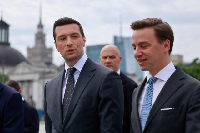 French far-right Rassemblement National (RN) party's President, member of the European Parliament and president of the Patriots for Europe (PfE) group Jordan Bardella (L) and Poland's ultranationalist Confederation party (Konfederacja) president and Deputy Marshal of the Sejm of the Republic of Poland Krzysztof Bosak   attend a ceremony at the tomb of the Unknown Soldier at the Marshal Jozef Pilsudski Square in Warsaw, Poland on June 18, 2026. Jordan Bardella is in Warsaw to meet with leaders of Polands far right, marking the latest stop on his overseas tour aimed at strengthening his European alliances just a few months before the French presidential election. (Photo by Wojtek RADWANSKI / AFP)