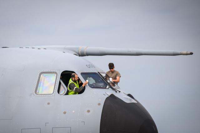 French airforce soldiers clean the window of an Airbus military A400M Atlas plane after a joint military drill flight between French army and German army, at the 123 airforce Orleans-Bricy base in Bricy center France, on June 11, 2026.  (Photo by Loic VENANCE / AFP)