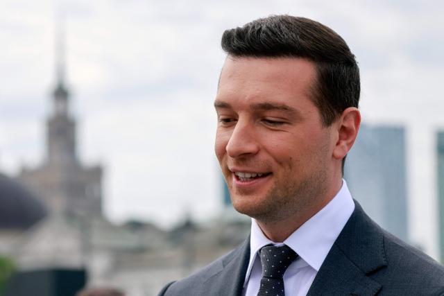 French far-right Rassemblement National (RN) party's President, member of the European Parliament and president of the Patriots for Europe (PfE) group Jordan Bardella attends a ceremony at the tomb of the Unknown Soldier at the Marshal Jozef Pilsudski Square in Warsaw, Poland on June 18, 2026. Jordan Bardella is in Warsaw to meet with leaders of Poland’s far right, marking the latest stop on his overseas tour aimed at strengthening his European alliances just a few months before the French presidential election. (Photo by Wojtek RADWANSKI / AFP)