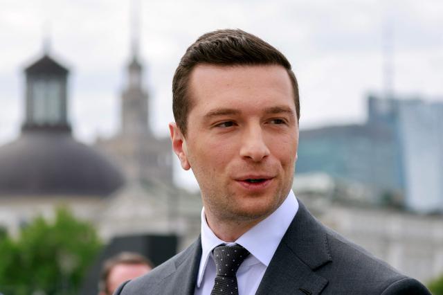 French far-right Rassemblement National (RN) party's President, member of the European Parliament and president of the Patriots for Europe (PfE) group Jordan Bardella attends a ceremony at the tomb of the Unknown Soldier at the Marshal Jozef Pilsudski Square in Warsaw, Poland on June 18, 2026. Jordan Bardella is in Warsaw to meet with leaders of Poland’s far right, marking the latest stop on his overseas tour aimed at strengthening his European alliances just a few months before the French presidential election. (Photo by Wojtek RADWANSKI / AFP)