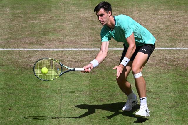 Hungary's Fabian Marozsan returns the ball to US' Taylor Fritz during their men's singles round of 16 tennis match of the Halle Open ATP tennis tournament in Halle, western Germany, on June 18, 2026. (Photo by CARMEN JASPERSEN / AFP)