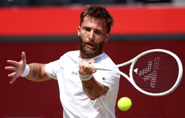 France's Corentin Moutet returns against Spain's Alejandro Davidovich Fokina during their men's singles round of 16 tennis match on day three of the ATP HSBC Championships at Queen's Club in west London on June 18, 2026. (Photo by Henry NICHOLLS / AFP)