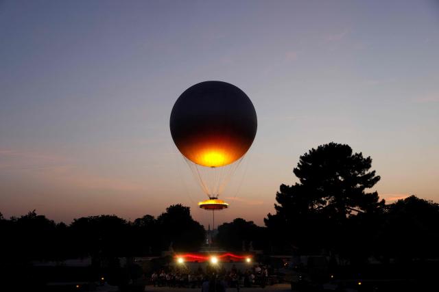 (FILES) The reinstallation of the 2024 Olympic cauldron designed by French designer Mathieu Lehanneur, is seen as it lifts off to the notes of an unreleased song by the late French singer Daniel Balavoine, during a free concert to mark France's annual street music festival, 'Fete de la Musique', at the Jardin des Tuileries, in Paris on June 21, 2025. Like every year the French midsummer Festival of Music also known as Fete de la Musique is set to take place in France, on the day of summer solstice June 21. (Photo by GEOFFROY VAN DER HASSELT / AFP)