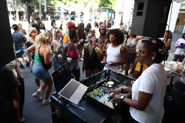 (FILES) Music enthusiasts listen to a DJ performing in a cafe during the French midsummer Festival of Music (Fete de la Musique) in Paris on June 21, 2025. Like every year the French midsummer Festival of Music also known as Fete de la Musique is set to take place in France, on the day of summer solstice June 21. (Photo by ROMAIN PERROCHEAU / AFP)