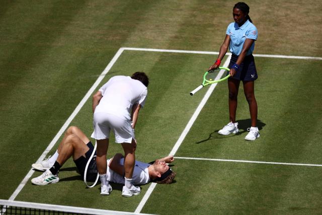 France's Corentin Moutet checks on Spain's Alejandro Davidovich Fokina after he divied to play a return against Moutet during their men's singles round of 16 tennis match on day three of the ATP HSBC Championships at Queen's Club in west London on June 18, 2026. (Photo by Henry Nicholls / AFP)