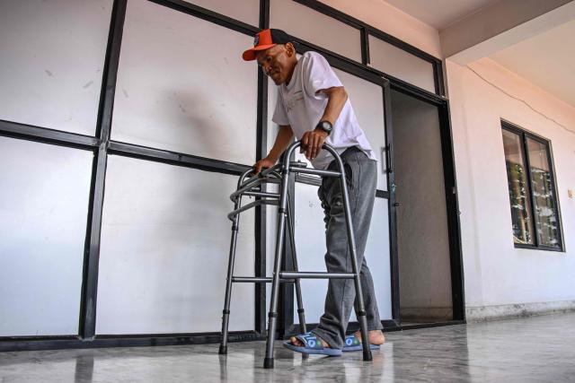 Everest survivor Dawa Sherpa walks with a support during his recovery in Kathmandu on June 18, 2026. (Photo by Prakash MATHEMA / AFP)