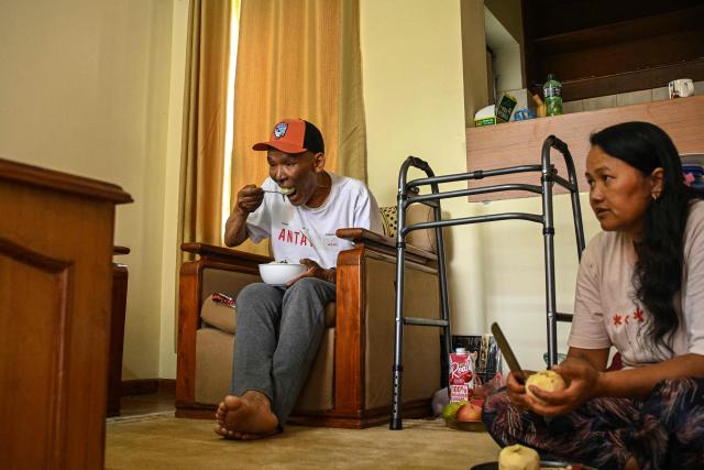 Everest survivor Dawa Sherpa (L) eats lunch during his recovery at a hotel in Kathmandu on June 18, 2026. (Photo by Prakash MATHEMA / AFP)
