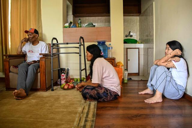 Everest survivor Dawa Sherpa's wife Damu Sherpa (C) and daughter Mendo Lhamu Sherpa (R) look at him as he speaks during an interview with AFP in Kathmandu on June 18, 2026. (Photo by Prakash MATHEMA / AFP)