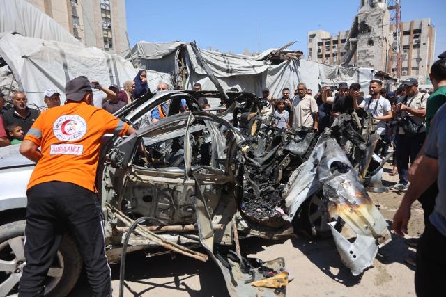 Palestinians gather at the site where a vehicle was targeted by an Israeli airstrike in Gaza City on June 18, 2026. A ceasefire has been in place in Gaza since October, but Israel reserves the right to strike targets it deems a threat. The territory remains gripped by daily violence as Israeli strikes continue, with both the military and Hamas accusing one another of violating the truce. (Photo by Omar AL-QATTAA / AFP)