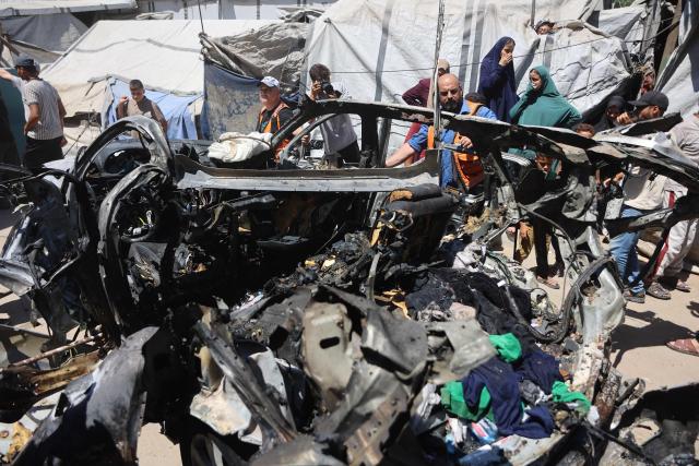 Palestinians gather at the site where a vehicle was targeted by an Israeli airstrike in Gaza City on June 18, 2026. A ceasefire has been in place in Gaza since October, but Israel reserves the right to strike targets it deems a threat. The territory remains gripped by daily violence as Israeli strikes continue, with both the military and Hamas accusing one another of violating the truce. (Photo by Omar AL-QATTAA / AFP)