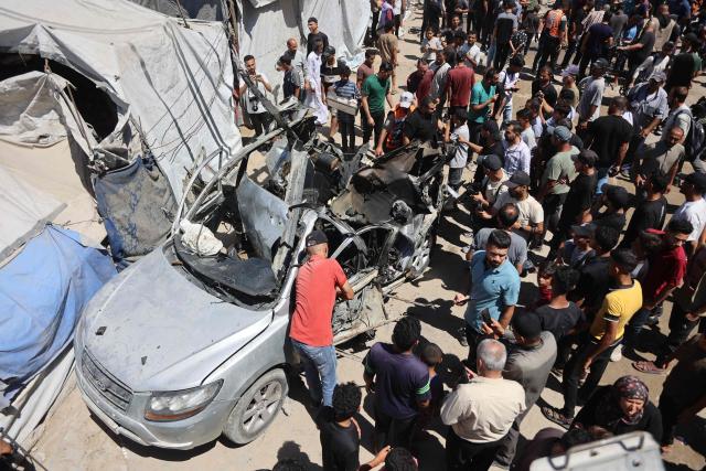 Palestinians gather at the site where a vehicle was targeted by an Israeli airstrike in Gaza City on June 18, 2026. A ceasefire has been in place in Gaza since October, but Israel reserves the right to strike targets it deems a threat. The territory remains gripped by daily violence as Israeli strikes continue, with both the military and Hamas accusing one another of violating the truce. (Photo by Omar AL-QATTAA / AFP)