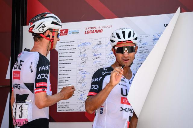 AE Team Emirates-XRG's Ecuadorian rider Jhonatan Narvaez (R) reacts next to teammate Austrian rider Felix Grossschartner during the team presentation of the second stage of the Men’s Tour of Switzerland (Tour de Suisse) cycling race in Locarno, Switzerland, on June 18, 2026. (Photo by Fabrice COFFRINI / AFP)