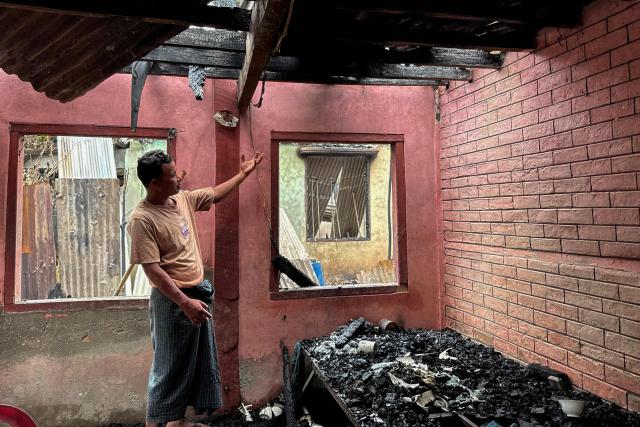 A man points to the damage in a building after an airstrike by Myanmar's military in Kyauktaw, western Rakhine State on June 18, 2026. A Myanmar military airstrike has killed seven civilians including a five-year-old child in the country's conflict-ravaged west, a witness and a rescue worker said on June 18. (Photo by AFP)