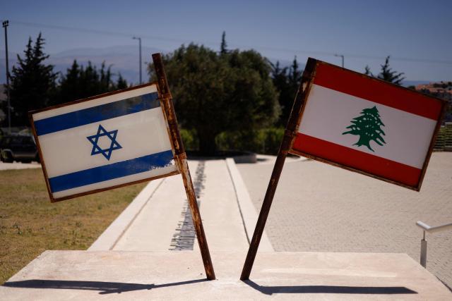 Israeli and Lebanese flags are pictured at a monument called the "Good Fence" in the northern town of Metula bordering Lebanon on June 18, 2026. Israeli strikes in south Lebanon killed three people on June 18, according to Lebanese state media, hours after the United States and Iran signed an agreement to end the Middle East war. Israel's military, meanwhile, announced the death of one of its soldiers the night before in an incident in south Lebanon that also left seven others wounded. (Photo by Jalaa MAREY / AFP)