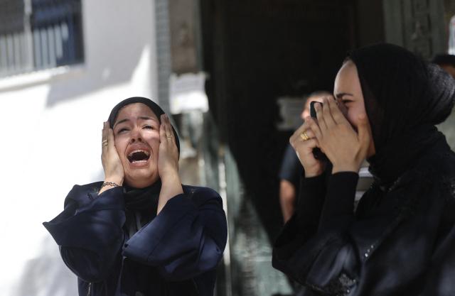 EDITORS NOTE: Graphic content / Displaced Palestinian women mourn the death of a man killed in an Israeli airstrike, prior to being taken for burial from the Al-Shifa Hospital in Gaza City, on June 18, 2026. A ceasefire has been in place in Gaza since October, but Israel reserves the right to strike targets it deems a threat. The territory remains gripped by daily violence as Israeli strikes continue, with both the military and Hamas accusing one another of violating the truce. (Photo by Omar AL-QATTAA / AFP)