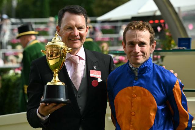 Trainer Aidan O'Brien (L) and Jockey Ryan Moore pose with the gold cup after winning the The Gold Cup race on the third day of the Royal Ascot horse racing meeting in Ascot, west of London, on June 18, 2026. (Photo by JUSTIN TALLIS / AFP)