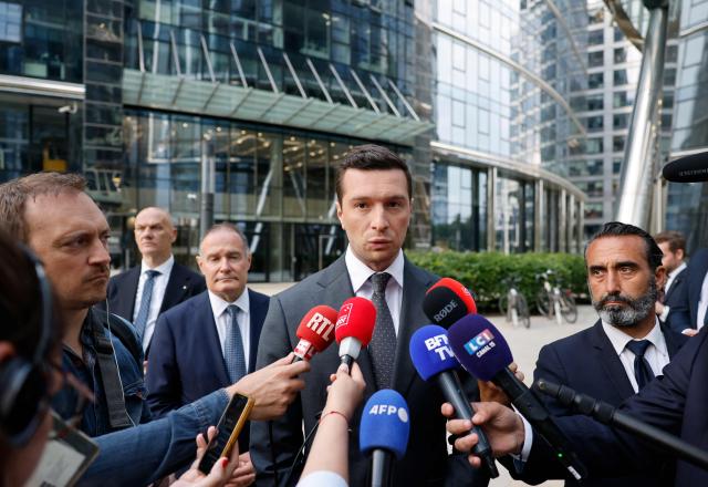 Jordan Bardella, French far-right Rassemblement National (RN) party's President, member of the European Parliament and president of the Patriots for Europe (PfE) group speaks to journalists in front of the Frontex, the European Border and Coast Guard Agency building next to Rassemblement National (RN) party member and former head of the EU's border agency Frontex Fabrice Leggeri in Warsaw, Poland on June 18, 2026. Jordan Bardella is in Warsaw to meet with leaders of Polands far right, marking the latest stop on his overseas tour aimed at strengthening his European alliances just a few months before the French presidential election. (Photo by Wojtek RADWANSKI / AFP)