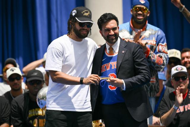New York City Mayor Zohran Mamdani (R) gives New York Knicks' #11 Jalen Brunson the Keys of the City during a championship celebration and Key to the City ceremony at City Hall Plaza after a ticker-tape parade honoring the team's NBA Finals victory in New York City on June 18, 2026. (Photo by ANGELA WEISS / AFP)