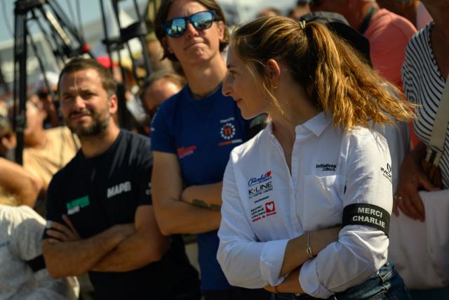 French skipper Violette Dorange wears an armband to pay tribute to late French skipper Charlie Dalin, before the podium ceremony of the Vendee Arctique solo sailing race, in Les Sables-d'Olonne on June 18, 2026. French offshore sailor and Vendee Globe 2024/2025 winner Charlie Dalin has died in Quimper, western France, aged 42, from cancer, his family announced on June 11, 2026. (Photo by Loic VENANCE / AFP)