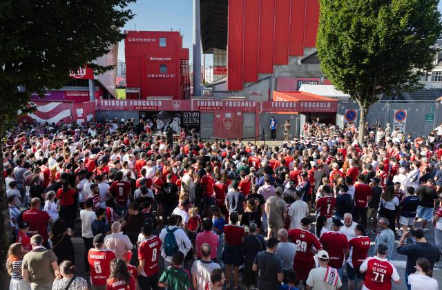Attendees gather at the entrance of the Francis-Le Ble stadium in Brest, western France on June 18, 2026 to pay tribute to the  coach Eric Roy who died on day prior. Brest coach Eric Roy, 58, has died from pancreatic cancer on June 17, his family announced on via the late manager’s Instagram account. (Photo by Fred TANNEAU / AFP)