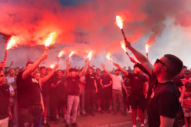 Attendees light flares as they gather at the entrance of the Francis-Le Ble stadium in Brest, western France on June 18, 2026 to pay tribute to the  coach Eric Roy who died on day prior. Brest coach Eric Roy, 58, has died from pancreatic cancer on June 17, his family announced on via the late manager’s Instagram account. (Photo by Fred TANNEAU / AFP)