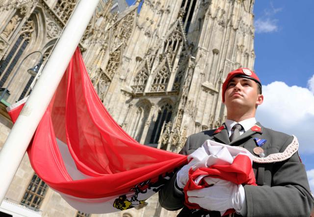 A soldier of the Austrian Honor guard holds the Austrian flag during the 330th anniversary celebrations of Habsburg traditional military Hoch und Deutschmeister outside of Saint Stephen’s cathedral on June 18, 2026 in Vienna, Austria. The "Hoch- und Deutschmeister" (K.u.K. Infanterie-Regiment Nr. 4) was one of the most prestigious and famous traditional military units of the Habsburg Empire, with origins dating back to 1696. (Photo by Joe Klamar / AFP)