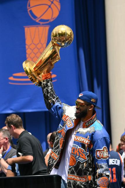 Karl-Anthony Towns #32 of the New York Knicks holds the Larry O'Brien Championship Trophy during a championship celebration and Key to the City ceremony at City Hall Plaza after a ticker-tape parade honoring the team's NBA Finals victory in New York City on June 18, 2026. (Photo by ANGELA WEISS / AFP)